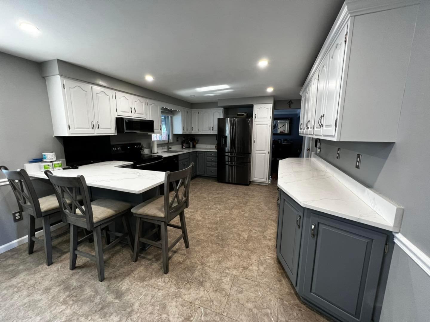 Same kitchen with white upper and gray lower cabinets after refinishing